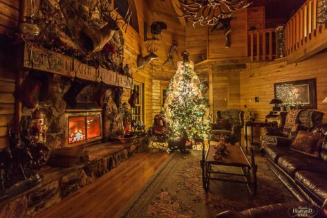 Original Lodge great room with Christmas tree and fireplace inside.